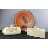 Two stoneware hot water bottles and a stoneware plate decorated with a bird.