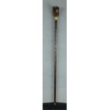 A walking cane with a carved treen Alsation head handle with yellow metal collar, 89cm long.