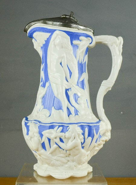 A Victorian jug; with a pewter lid, modelled with classical figures, and face mask to the handle.