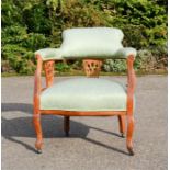 A Victorian mahogany tub chair, with pierced uprights, and upholstered in green silk.