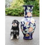 A large ceramic vase, dark blue ground, depicting sunflowers.