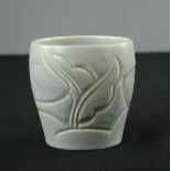 A Suzie Cooper cup, impressed with flowers, pale blue glaze.