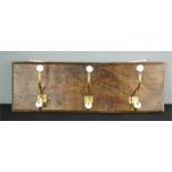 An oak panel coat rack with Victorian ceramic and gilt metal hooks.