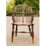 An elm Windsor armchair, with pierced splat, and spindles piercing the bowed arm rail, H-form