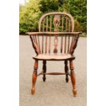 An elm Windsor armchair, with pierced splat, and spindles piercing the bowed arm rail, H-form