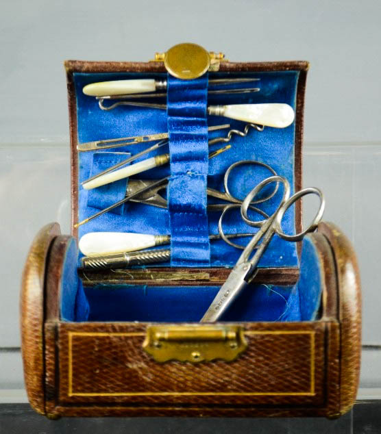 A Victorian leather bound sewing box, with contents and silk blue lining, together with a pair of