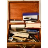 A wooden case containing fountain pens, pencils, biros etc by various makers including Parker.