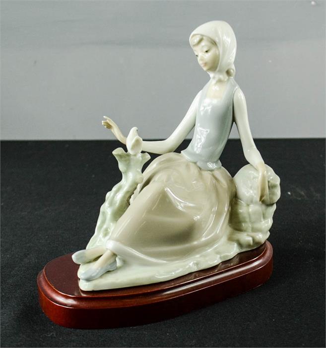 A Lladro figurine, girl seated beside a white bird, 17cm high. - Image 2 of 3