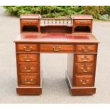 A 19th century mahogany desk, with raised and railed back, and drawers flanking the recess, red
