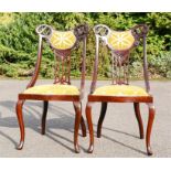 A pair of mahogany Edwardian chairs, with pierced splats and upholstered velvet seats.