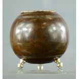 A lignum vitae bowling ball converted into a holder, raised on three knop feet.