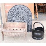 A cast iron fireback, cast iron fire basket, and a coal bucket.