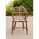 An elm Windsor armchair, with pierced splat, and spindles piercing the bowed arm rail, H-form