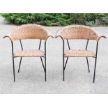 A pair of iron and rushworked armchairs.