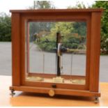 A Baird & Tatlock Chemist's balance/scales, in a mahogany glazed case.