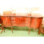 A mahogany sideboard, three long drawers flanked by cupboard doors.