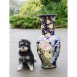 A large ceramic vase, dark blue ground, depicting flowers.