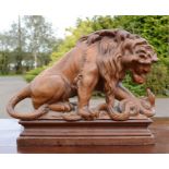 A carved treen lion & serpent, raised on a platform, 23 by 31 by 10½cm.