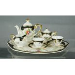 An antique porcelain miniature tea service, with gilded decoration.