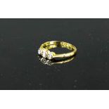 A yellow gold (tested 18ct) three stone diamond ring, 1.9g, size M.