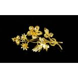 An 18ct gold (unmarked) and diamond brooch, in the form of a flower, with old rough cut diamonds set