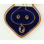 An amethyst pendant and matching stud earrings, the oval amethysts with spiral borders, 10.2g in