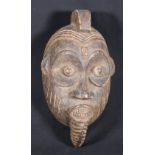 Nigerian Igbo mask with protruding eyes and mouth with prominent teeth,