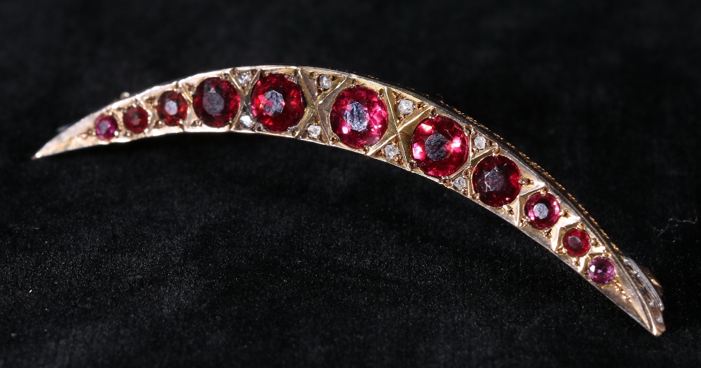 9ct gold crescent moon brooch set with eleven pink rubies flanked by diamond chips, approx 4.