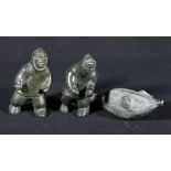 Inuit stone carving of two male figures pulling trapped seal