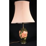 Moorcroft orchid pattern lamp with green ground,