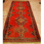 Ushak design runner with five lozenges on a red ground, 312cm x 125cm.