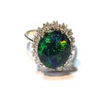 Dress ring with an oval doublet black opal surrounded by diamond brilliants, in white gold, 18ct.