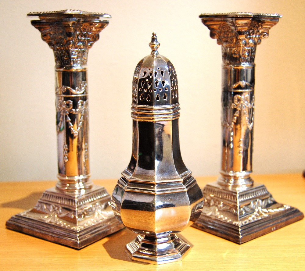 Silver octagonal sugar caster and a pair of classical Corinthian column candlesticks with swag