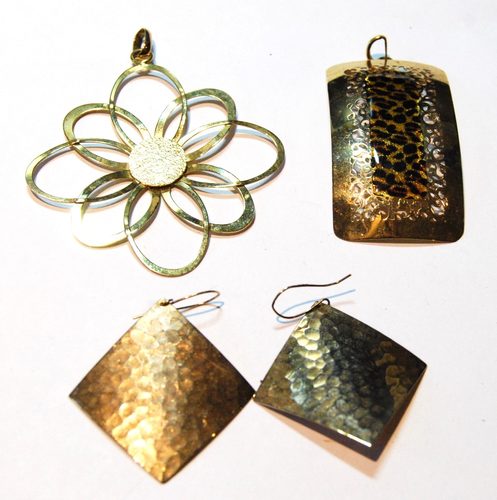 Gold whorl pendant, another of panel form, and a pair of square drop earrings.