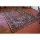 Antique Qashqai carpet, with four lozenges on a indigo field, some wear, 304cm x 210cm.