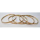 Five 9ct gold slave bangles, diamond-cut.