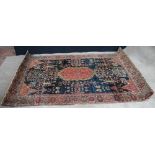 Antique Persian rug with red floral medallion on a indigo field with lotus flowers,