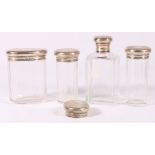 Set of four engine-turned silver covered glass toilet jars, with matching monogram,