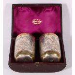 Pair of silver and gilt beakers decorated in the Oriental manner with cranes,