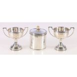 Pair of miniature silver trophy cups, 7cm and a cylindrical silver covered jar, 6.5cm, 111g gross.