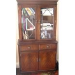 Reproduction mahogany two-door bookcase with two drawers and two cupboards below, on square feet.
