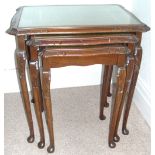 Nest of three mahogany tea tables on cabriole legs with green and gilt tops.