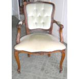 French style walnut button-back armchair, upholstered in pale gold coloured fabric.