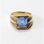 Synthetic blue spinel ring, trap-cut, in gold, '10K'.
