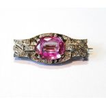 Plaque brooch with oval pink stone upon pave-set eight-cut diamonds in gold and platinum.