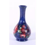 Moorcroft poppy pattern bottle shaped vase, with blue ground, partial paper label, 15.5cm.