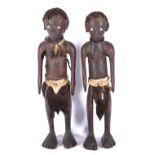 Two carved African figures with inlaid eyes and skin belt and skirt, real hair to the scalp,