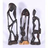 Three African Makonde carved wood figures depicting elongated stylised figures, 40cm.