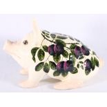 Griselda Hill pottery model of a pig decorated with plums, painted green signature to base, 41cm.