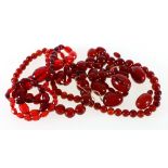 Strand of over forty graduated red amber beads, the largest bead 9.5g, 3cm long, etc.